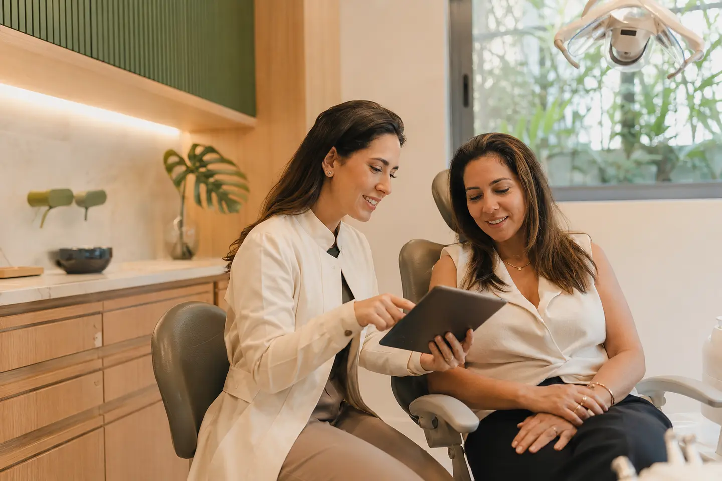 Dentista e paciente conversando durante uma avaliação odontológica